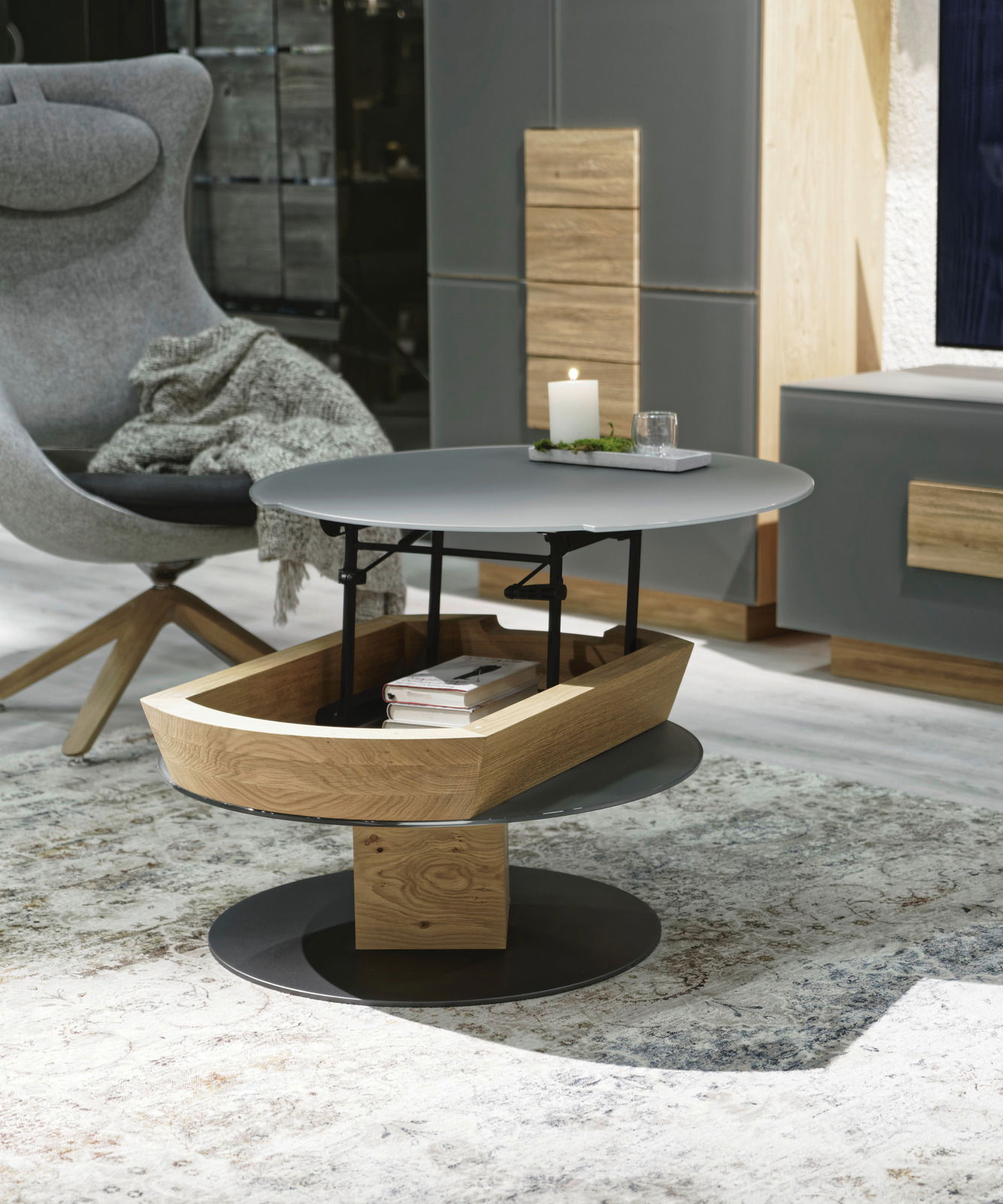 Moderner Couchtisch mit runder, grauer Tischplatte und Holzdetails, seitliche Perspektive