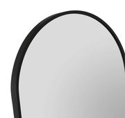 Nahaufnahme eines Standspiegels mit schwarzem Rahmen, perspektivisch von der Seite aufgenommen.