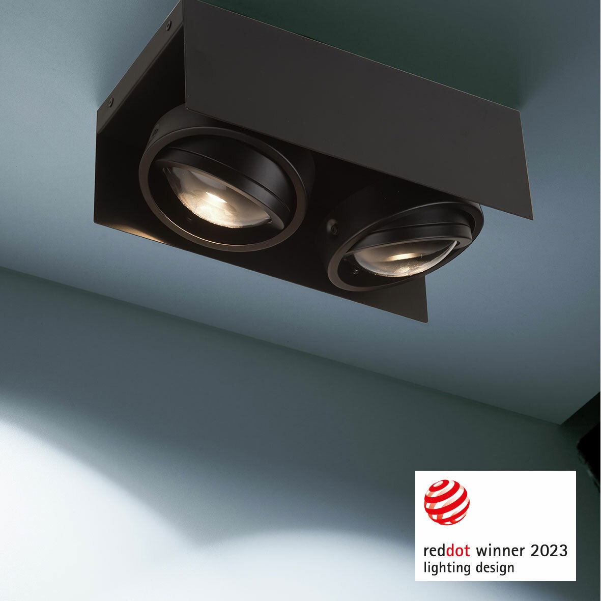 Moderne LED Aufbauleuchte mit zwei runden Strahlern, von unten betrachtet, ausgezeichnet mit dem Red Dot Award 2023 für Lichtdesign.