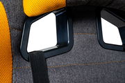Detailansicht der Rückseite eines Gaming-Stuhls mit schwarzem Rahmen und gelben Polsterungen.