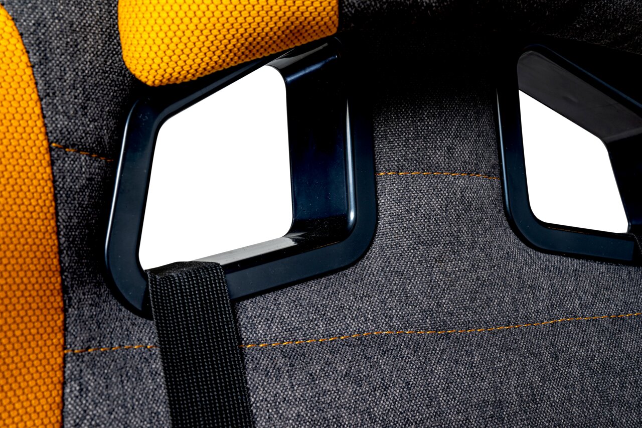 Detailfoto van de achterkant van een gamingstoel met een zwart frame en gele bekleding.