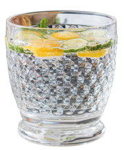 Nahaufnahme eines dekorativen Glases mit eingelegten Zitronen- und Gurkenscheiben, gefüllt mit sprudelndem Wasser.