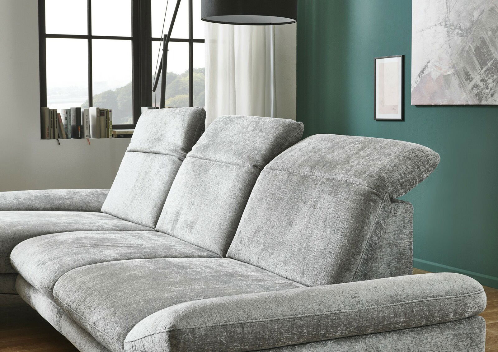 Graues Longchair-Sofa in einem modernen Wohnzimmer, seitliche Perspektive