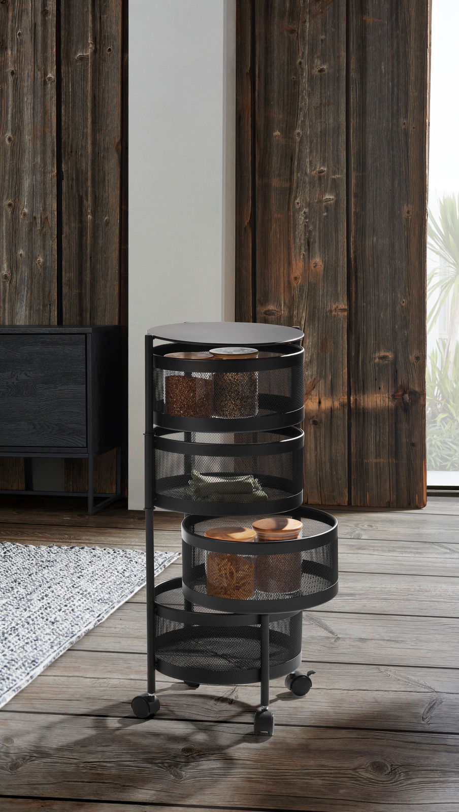 Moderner Allzweckwagen mit drei runden, schwarzen Gitterablagen auf Rollen, seitliche Perspektive.