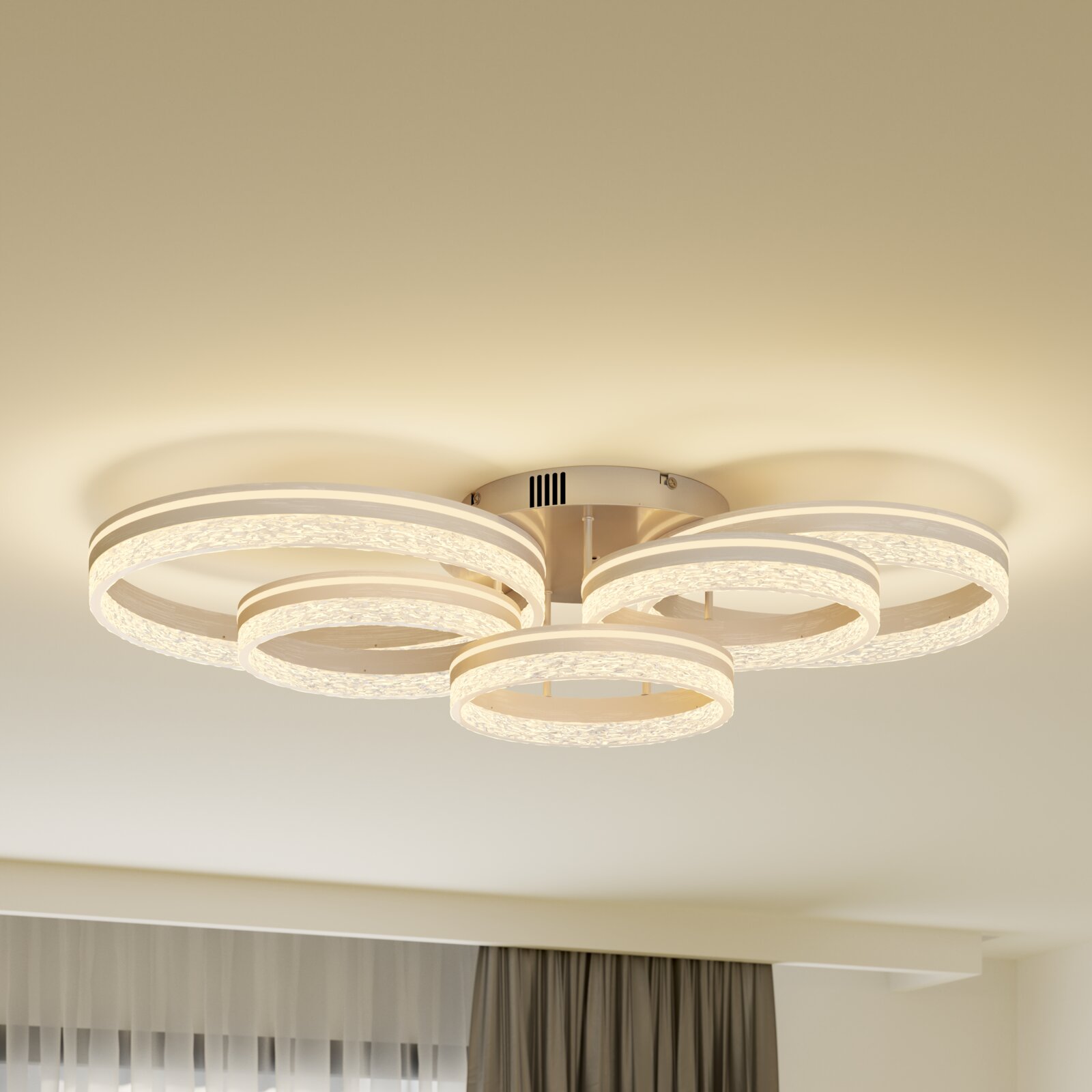 Moderne LED-Deckenleuchte mit vier leuchtenden, kristalloptischen Ringen in warmweiß, Ansicht von unten in leicht seitlicher Perspektive an der Zimmerdecke