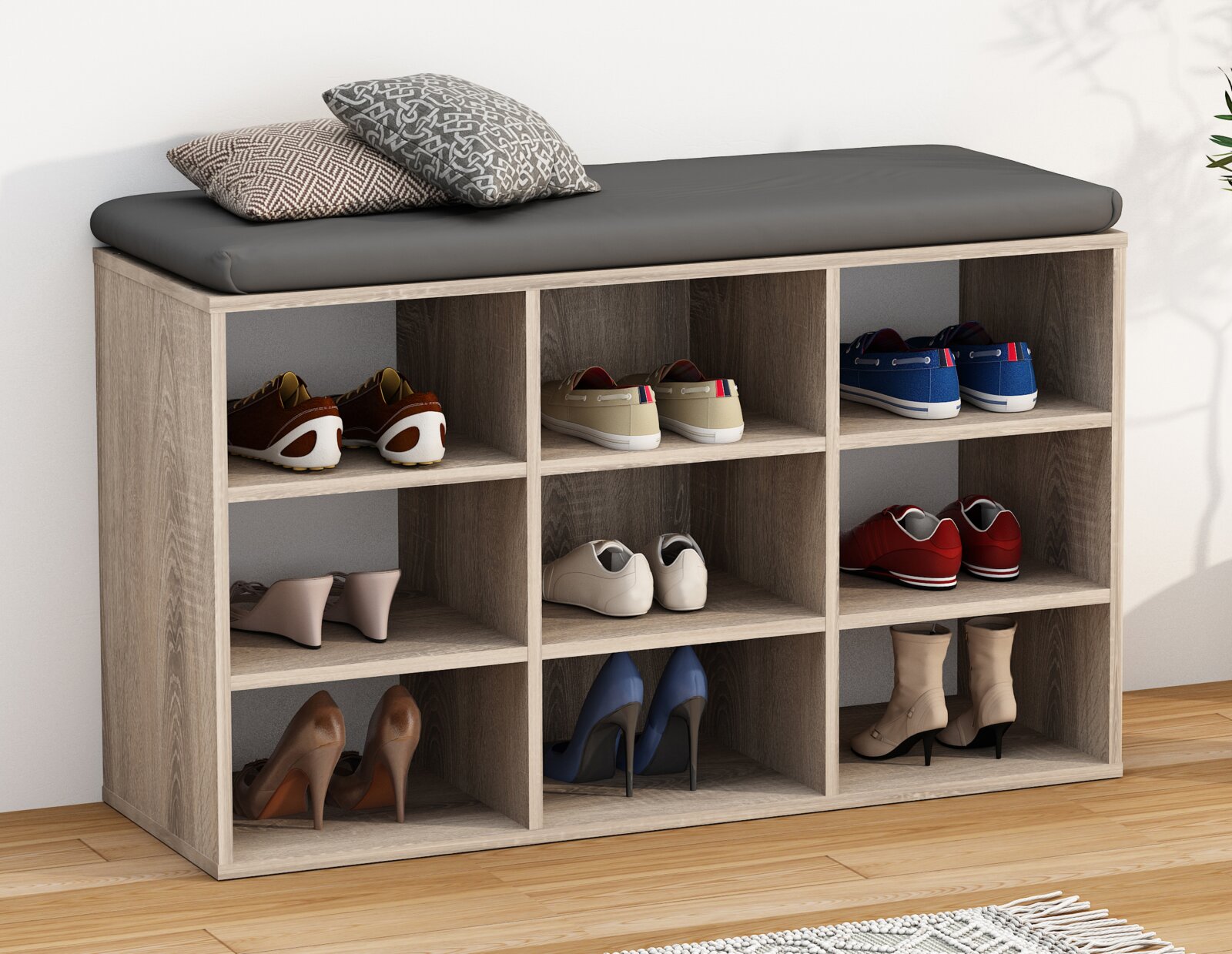 Schuhbank aus Holzoptik mit grauem Sitzpolster und neun offenen Fächern, gefüllt mit Schuhen; Ansicht schräg von vorne
