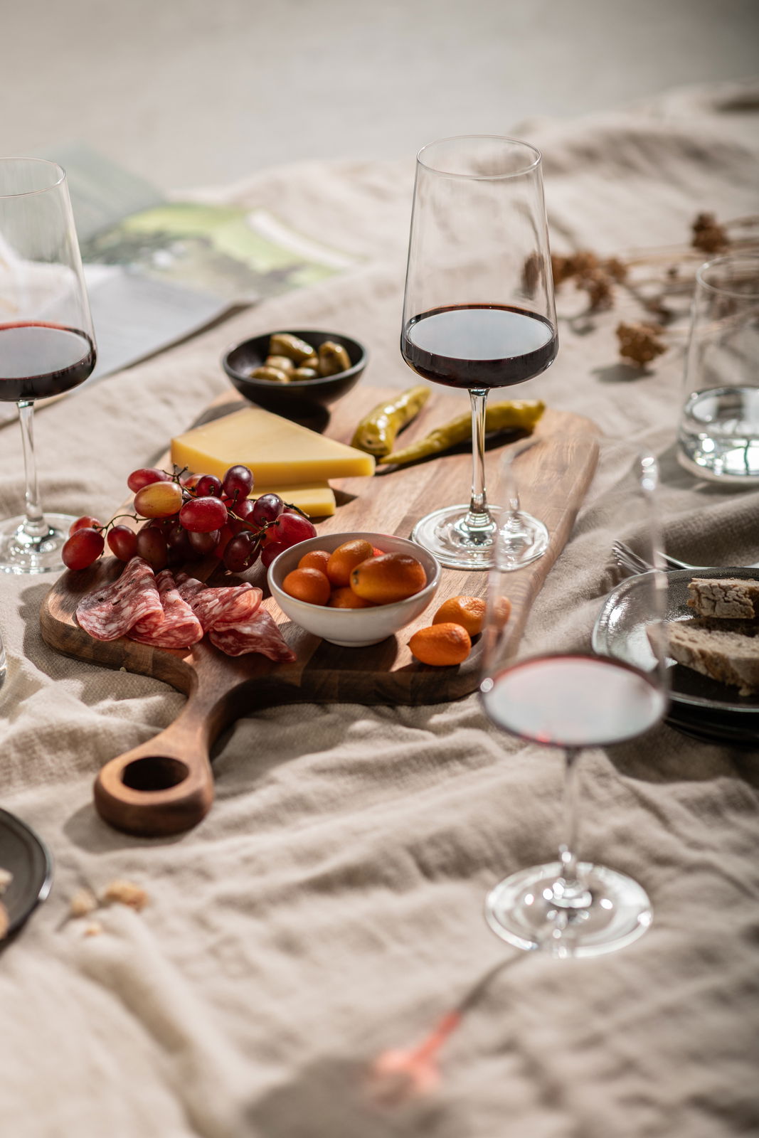 SCHOTT ZWIESEL Rotweinglas 4er-Set MIOVINO Ein stilvolles Rotweinglas-Set auf einem Tisch mit einer Auswahl an Käse, Trauben und Wurst, aus der Vogelperspektive fotografiert.