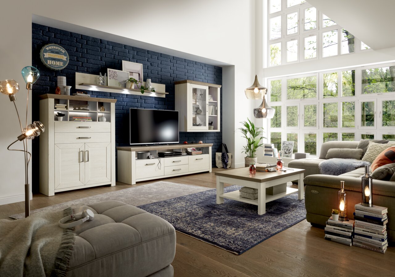 Set one by Musterring Lowboard SET ONE YORK Woonkamer met een moderne wandmeubelcombinatie, bestaande uit een hoogkast, een laagkast, een hangelement en een wandplank, in een lichte houtlook. Zijaanzicht met uitzicht op de volledige inrichting.
