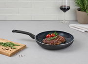 Pfanne mit gebratenem Steak, Kirschtomaten und Rosmarin, seitliche Perspektive