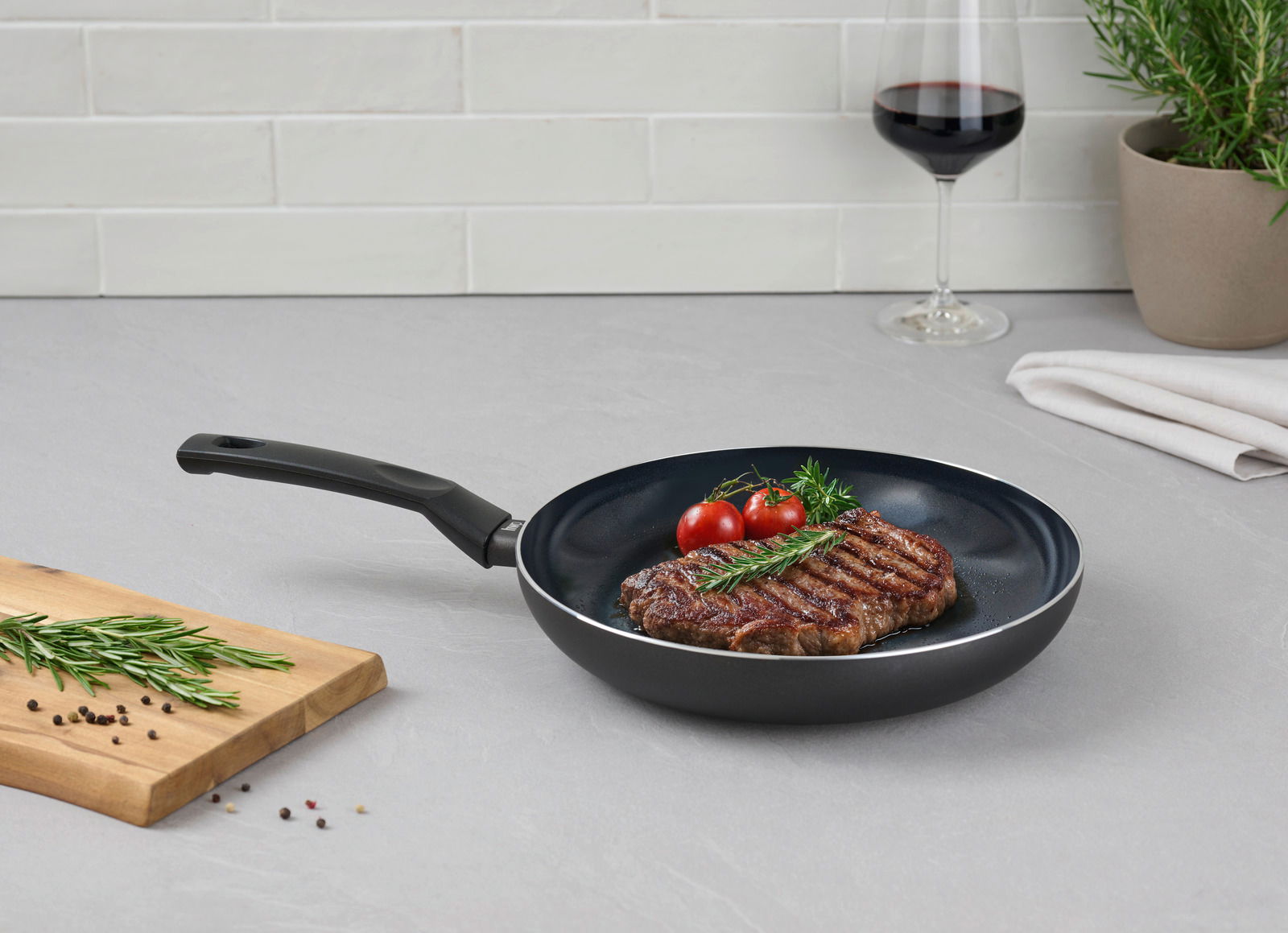 Pfanne mit gebratenem Steak, Kirschtomaten und Rosmarin, seitliche Perspektive