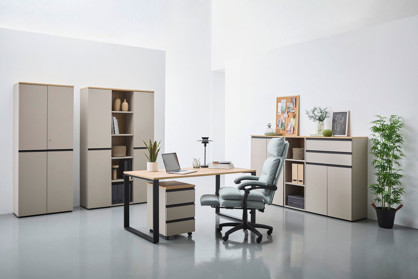 Novel Kombischrank DELTONA Moderne Büromöbel in einem hellen Raum, bestehend aus einem Schreibtisch mit Rollcontainer, mehreren Aktenschränken und einem ergonomischen Bürostuhl. Perspektive von vorne.