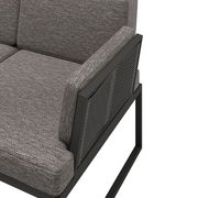 Detailansicht einer grauen Loungegarnitur mit Metallrahmen und gepolsterten Kissen, seitliche Perspektive.