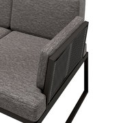 Detailansicht einer grauen Loungegarnitur mit Metallrahmen und gepolsterten Kissen, seitliche Perspektive.
