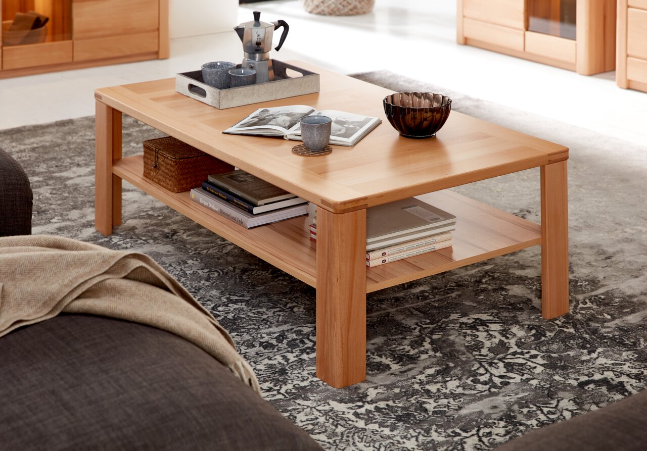 Moderner Couchtisch aus Holz mit Ablage, dekoriert mit Büchern, Tassen und einer Schale, seitliche Perspektive
