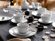 Elegantes Kaffeeservice Luna Black L, 18-teilig, auf einem gedeckten Tisch mit schwarzem Tischtuch, aus der Perspektive von schräg oben fotografiert.