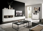 Moderne Wohnzimmer-Wandkombination in Weiß mit integriertem TV, dekorativen Vasen und Regalen, seitliche Perspektive.