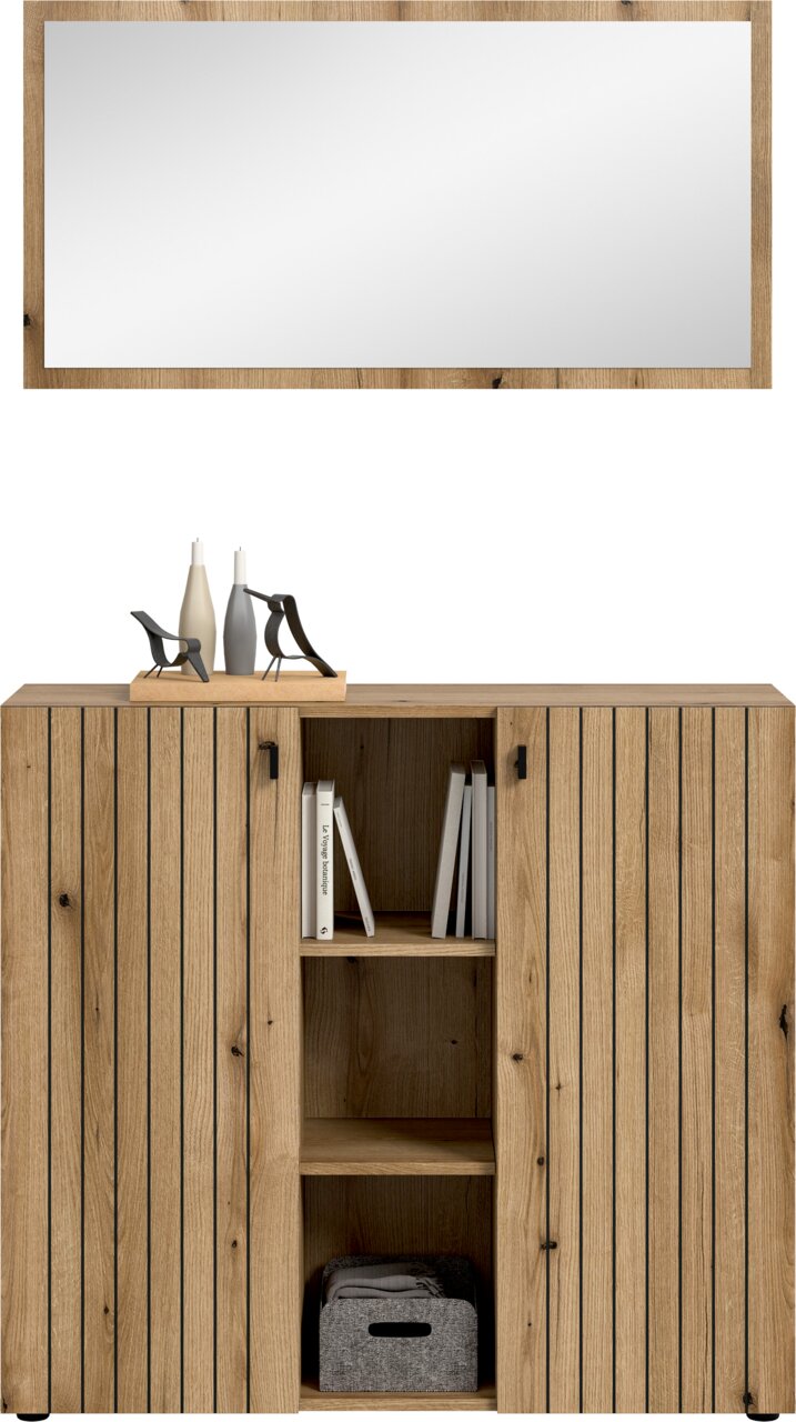 Frontansicht einer modernen Holz-Kommode/Sideboard in Eicheoptik mit zwei gerillten Türen, mittigem offenen Regal mit Büchern und Stoffbox sowie Deko auf der Oberseite vor weißem Hintergrund