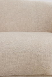 Nahaufnahme einer beigen Couch mit strukturierter Stoffoberfläche, Ansicht von vorne.