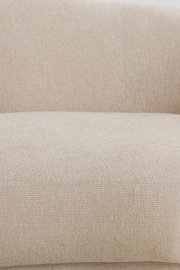 Nahaufnahme einer beigen Couch mit strukturierter Stoffoberfläche, Ansicht von vorne.