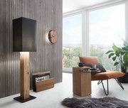 Große Stehleuchte mit schwarzem Schirm und Holzfuß, seitliche Perspektive in modernem Wohnzimmer.