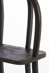 Nahaufnahme eines dunklen Holzstuhls mit geschwungenen Beinen, seitliche Perspektive