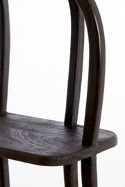 Nahaufnahme eines dunklen Holzstuhls mit geschwungenen Beinen, seitliche Perspektive