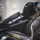 Nahaufnahme eines luxuriösen Massagesessels aus schwarzem Leder mit integrierter Steuerung an der Armlehne, seitliche Perspektive.