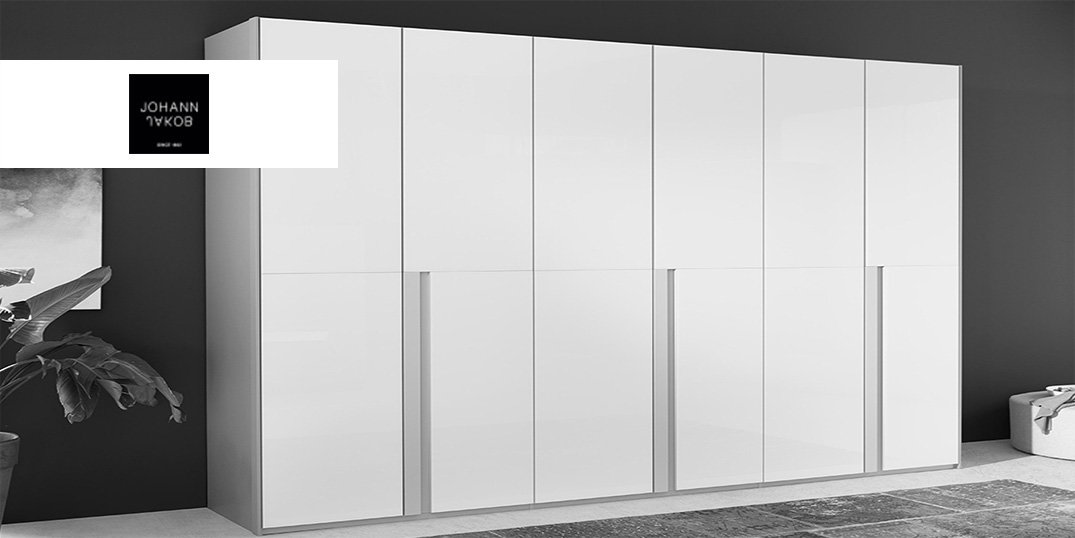Ein schlichter, moderner weißer Kleiderschrank mit glänzender Oberfläche, der vor einer dunklen Wand steht.