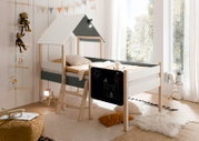 Kinder-Hausbett mit Dach und Leiter, seitliche Tafel mit Kreidezeichnung, gemütliche Kissen und Decken, seitliche Perspektive