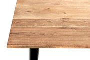 Nahaufnahme einer rechteckigen Tischplatte aus naturbelassenem Holz mit sichtbarer Maserung und Astlöchern, unten ein schwarzes Tischbein, Ansicht leicht von oben