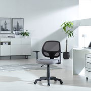 Moderner Drehstuhl mit Netzrückenlehne und grauem Sitzpolster, seitliche Perspektive in einem hellen Büro mit Pflanzen und Schreibtisch.