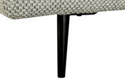 Nahaufnahme eines schwarzen Metallbeins eines Sofas mit grauem Stoffbezug, seitliche Perspektive