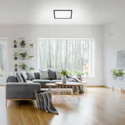 Moderne LED-Deckenleuchte in einem stilvollen Wohnzimmer, aus der Perspektive von unten betrachtet.