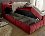 Rotes Boxspringbett mit hochgeklappter Matratze und Stauraum, seitliche Perspektive