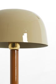 Nahaufnahme einer Tischleuchte mit glänzendem, beigem Schirm und braunem Ständer, seitliche Perspektive.