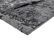 Nahaufnahme eines modernen, grauen Teppichs mit abstraktem Muster, Perspektive von der Seite.