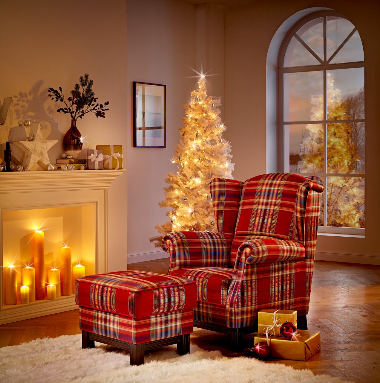 Vooraanzicht van een comfortabele rode fauteuil met klassiek ruitpatroon en bijpassende hocker in een sfeervol verlichte kerstsetting.