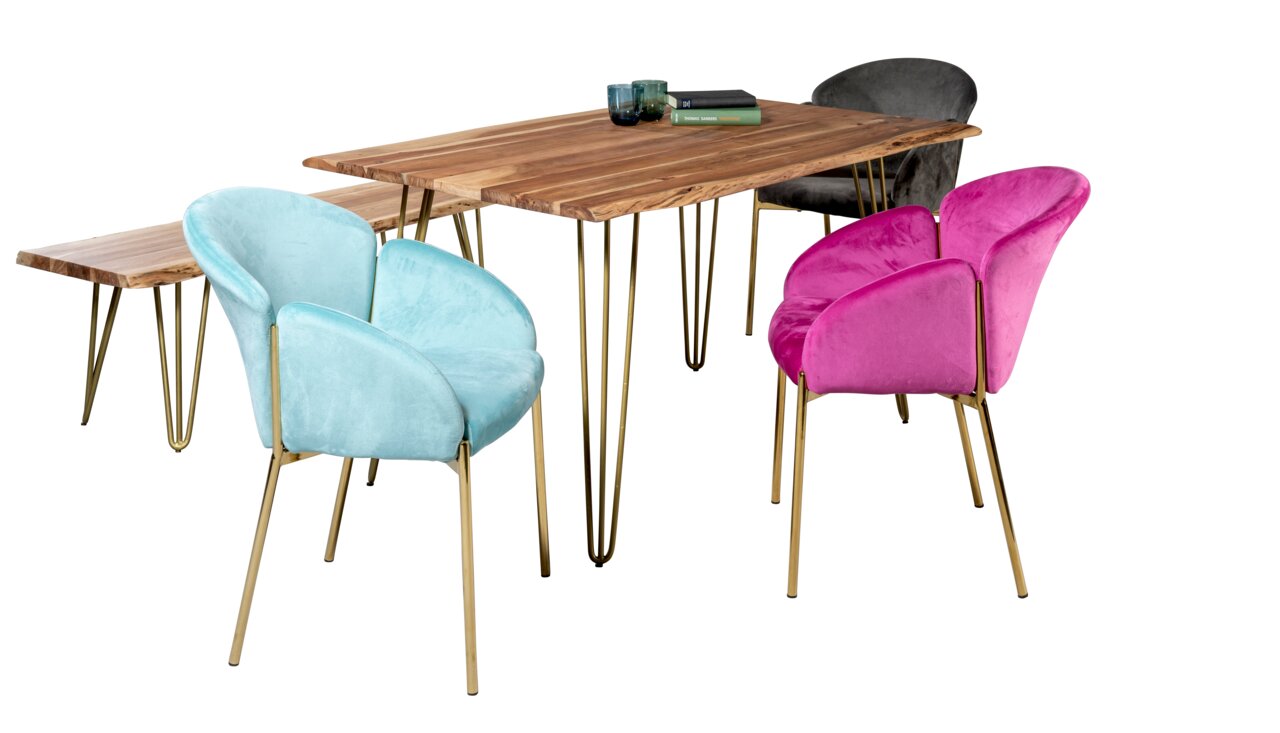 Eetkamer met een houten tafel en vier kleurrijke stoelen in turkoois, roze en grijs, gezien van voren.