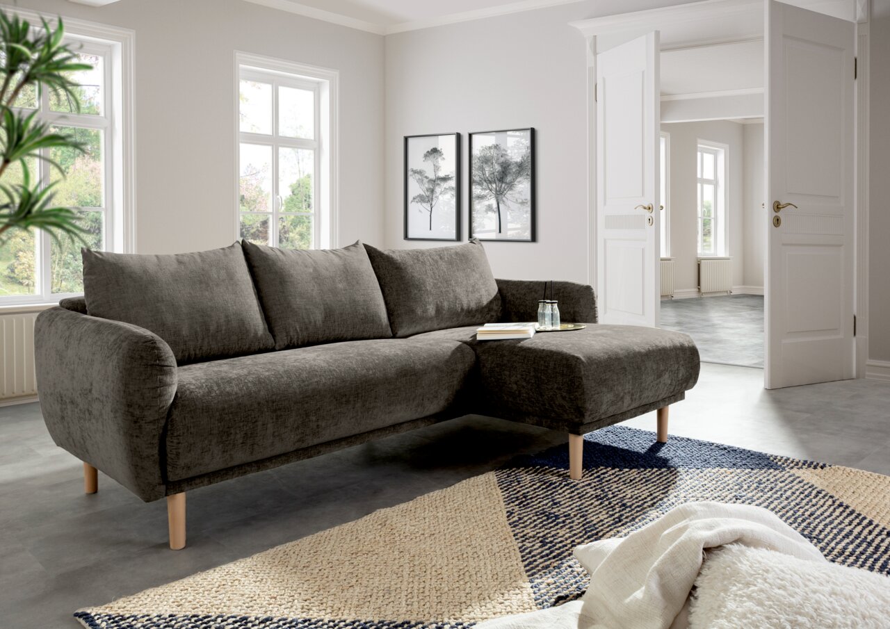 Graues Ecksofa mit Holzfüßen in einem modernen Wohnzimmer, seitliche Perspektive.