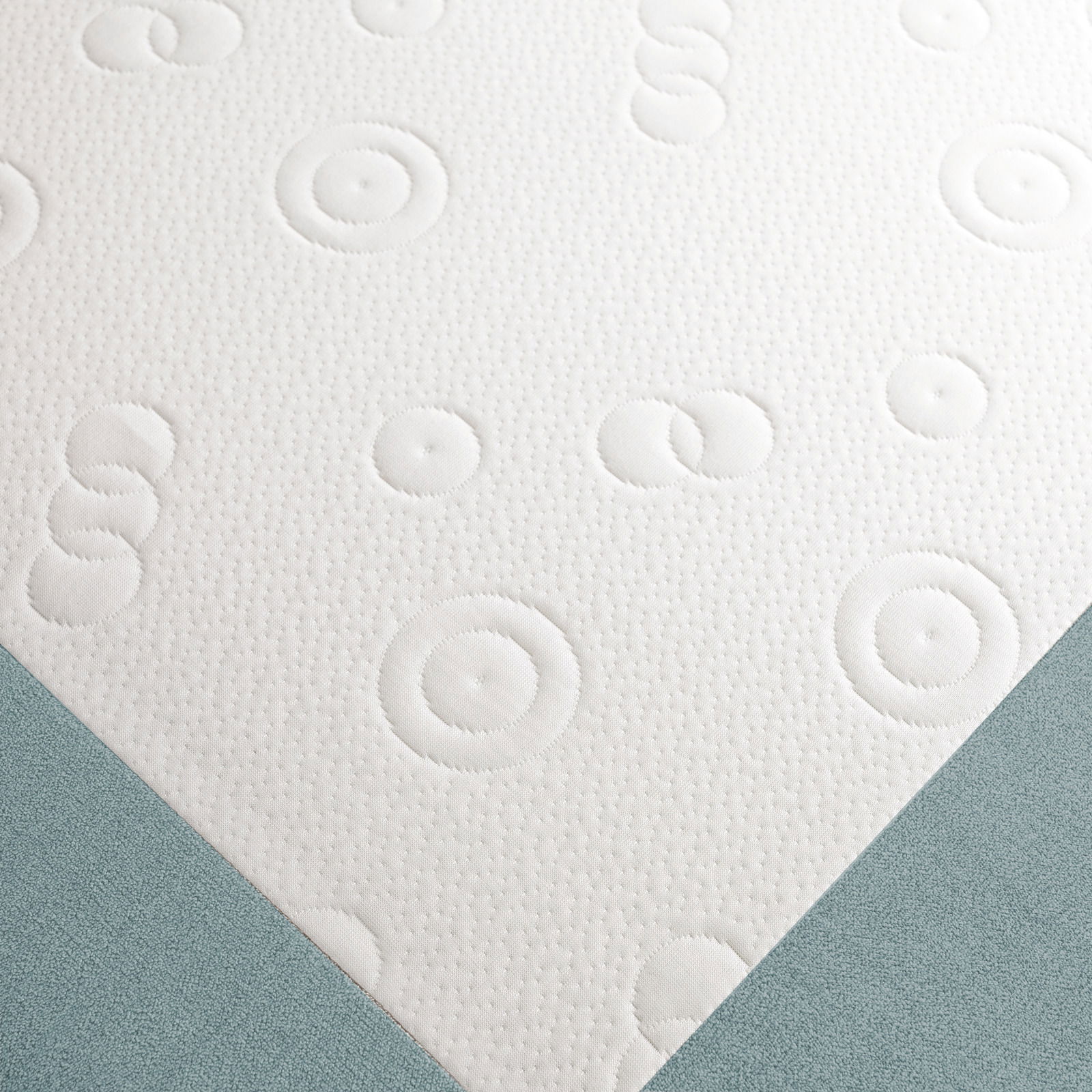 Nahaufnahme eines Funktionssofas mit weißem, gemustertem Stoff und blauer Polsterung, von oben betrachtet.