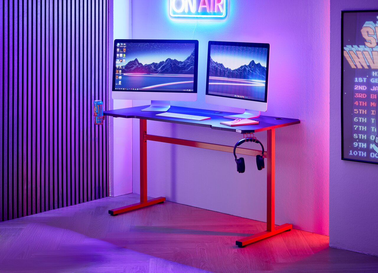 Moderne gamingtafel met twee beeldschermen, hoofdtelefoonhouder en bekerhouder, zijaanzicht