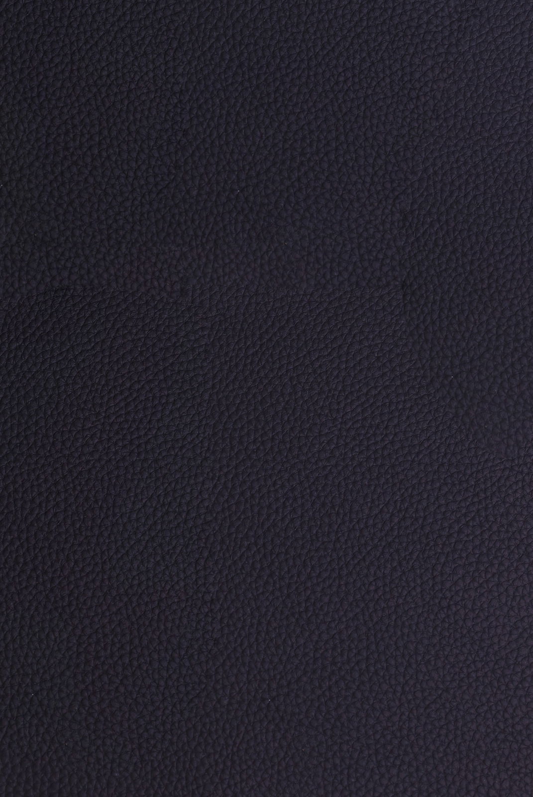 Nahaufnahme einer dunkelblauen, strukturierten Lederoberfläche, von oben betrachtet.