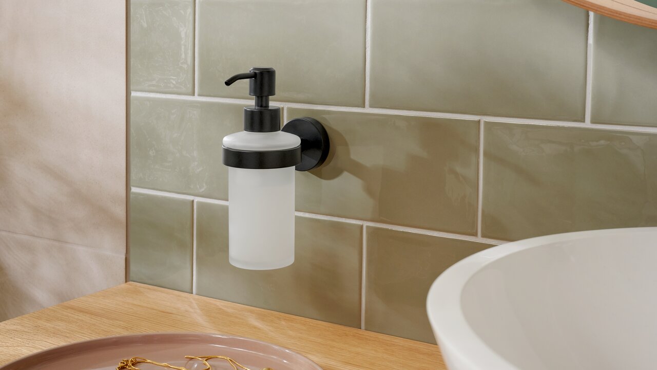 Wandgemonteerde tesa MOON BLACK zeepdispenser in een moderne badkamer, zijaanzicht