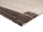 Nahaufnahme eines Teppichs mit braunen und beigen Streifen, perspektivisch von der Seite aufgenommen.