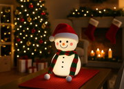 Frontalansicht einer leuchtenden Akku-Tischleuchte in Form eines Schneemanns mit Weihnachtsmütze und Schal, im Hintergrund ein festlich geschmückter Weihnachtsbaum und ein Kamin.