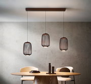Moderne LED-Hängeleuchte mit drei zylinderförmigen Lampenschirmen aus Metall, hängend über einem Esstisch, seitliche Perspektive.