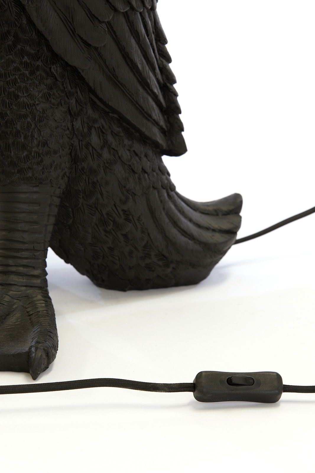 Nahaufnahme der Tischleuchte DUCK von Light&Living, die den Fuß und das detaillierte Federdesign zeigt, mit einem schwarzen Kabel und Schalter im Vordergrund.
