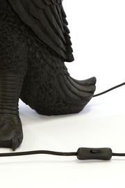 Nahaufnahme der Tischleuchte DUCK von Light&Living, die den Fuß und das detaillierte Federdesign zeigt, mit einem schwarzen Kabel und Schalter im Vordergrund.