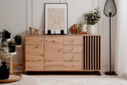 Modernes Sideboard aus Holz mit Schubladen und Türen, dekoriert mit Pflanzen und Kunstobjekten, frontal fotografiert.