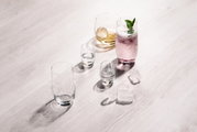 Verschiedene Gläser auf einem Tisch, darunter ein Bierbecher-Set aus vier Gläsern, aus der Vogelperspektive fotografiert.